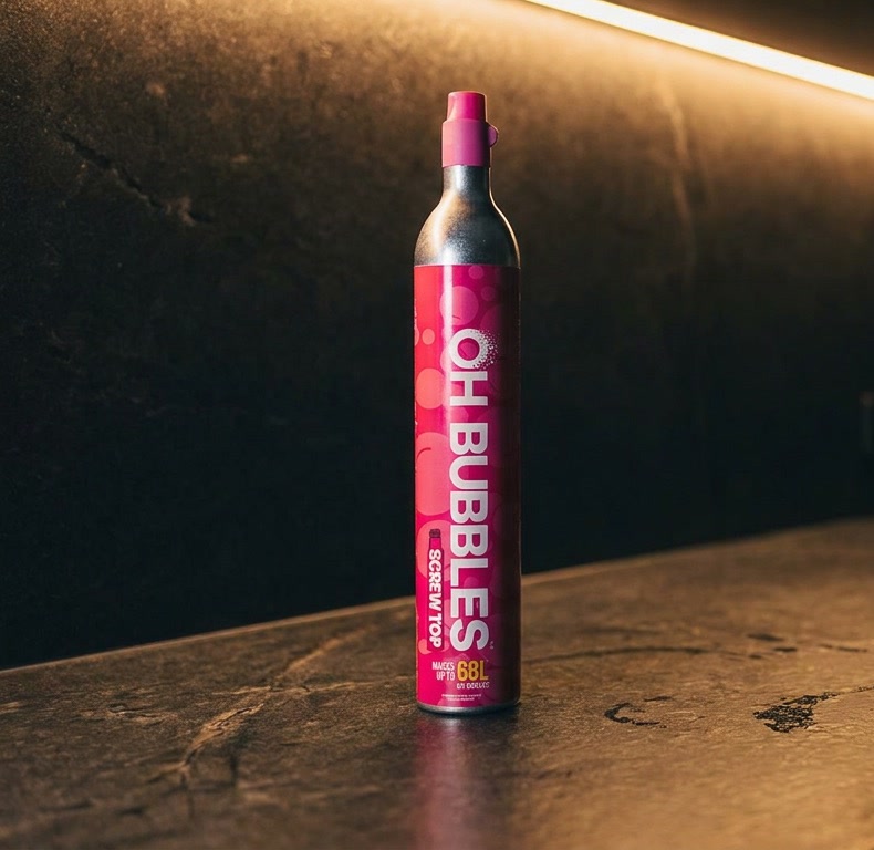 A spare OH Bubbles CO2 cylinder on the kitchen bench, lit by under-cabinet light late at night